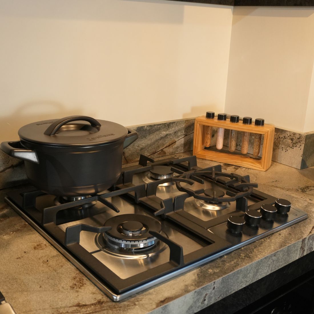 Cooktop Debacco com panelas em fogão de indução e grelha na bancada de granito preto.