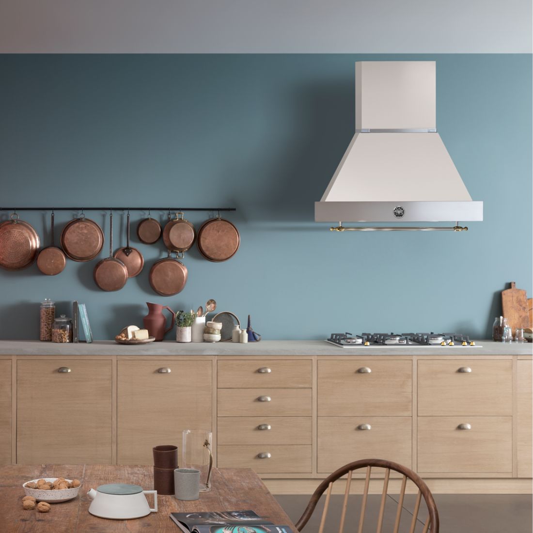 Coifa Bertazzoni Heritage de Parede Marfim 91cm em uma cozinha clásssica ao lado de panelas de cobre