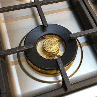 Queimador a gás do cooktop Bertazzoni com acabamento em latão e trempes de ferro fundido.