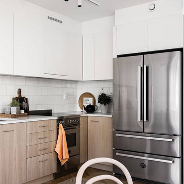 Cozinha moderna com refrigerador Bertazzoni French Door inox e armários claros, decoração minimalista.