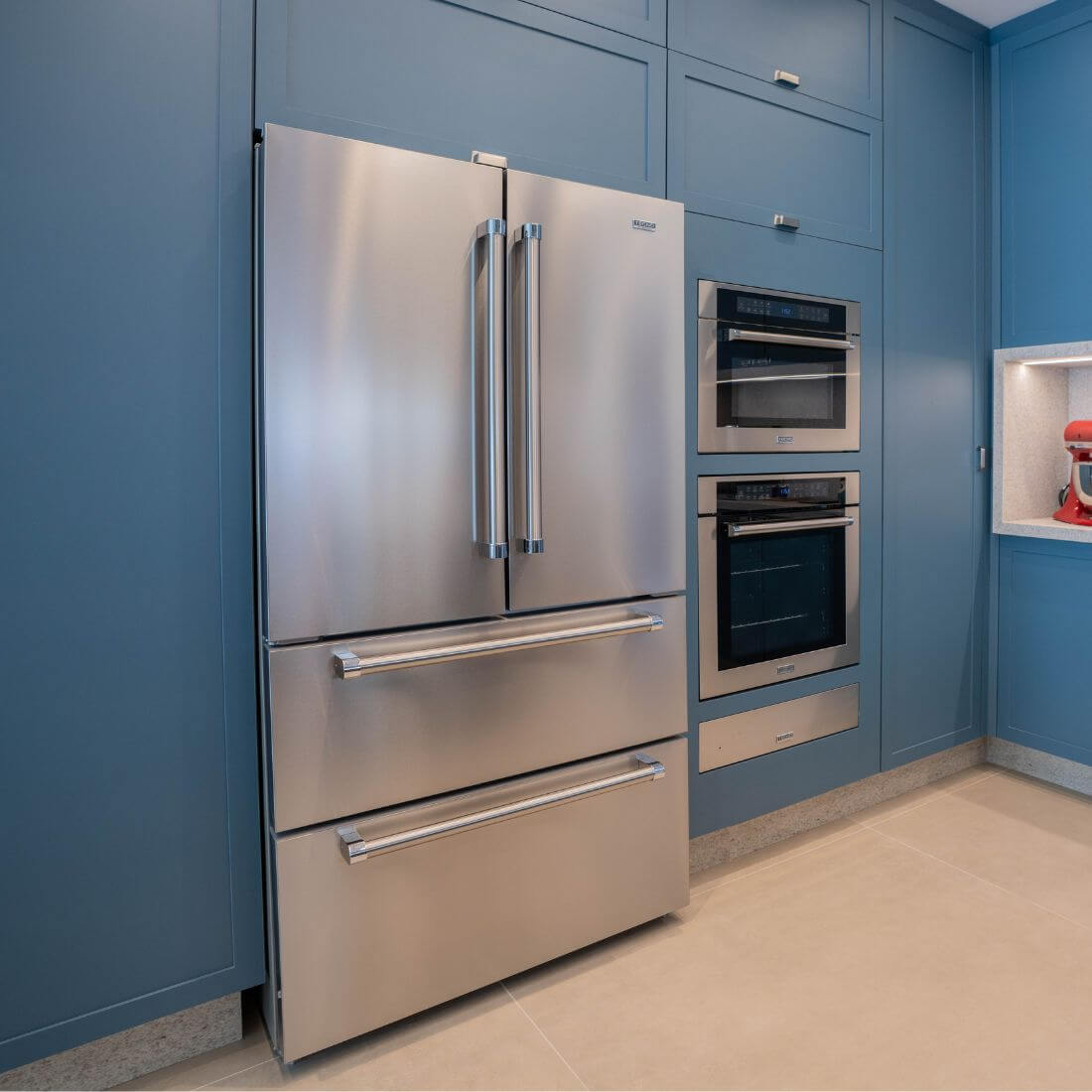 Refrigerador Tecno Professional French Door 571 litros inox em cozinha moderna com armários azuis.