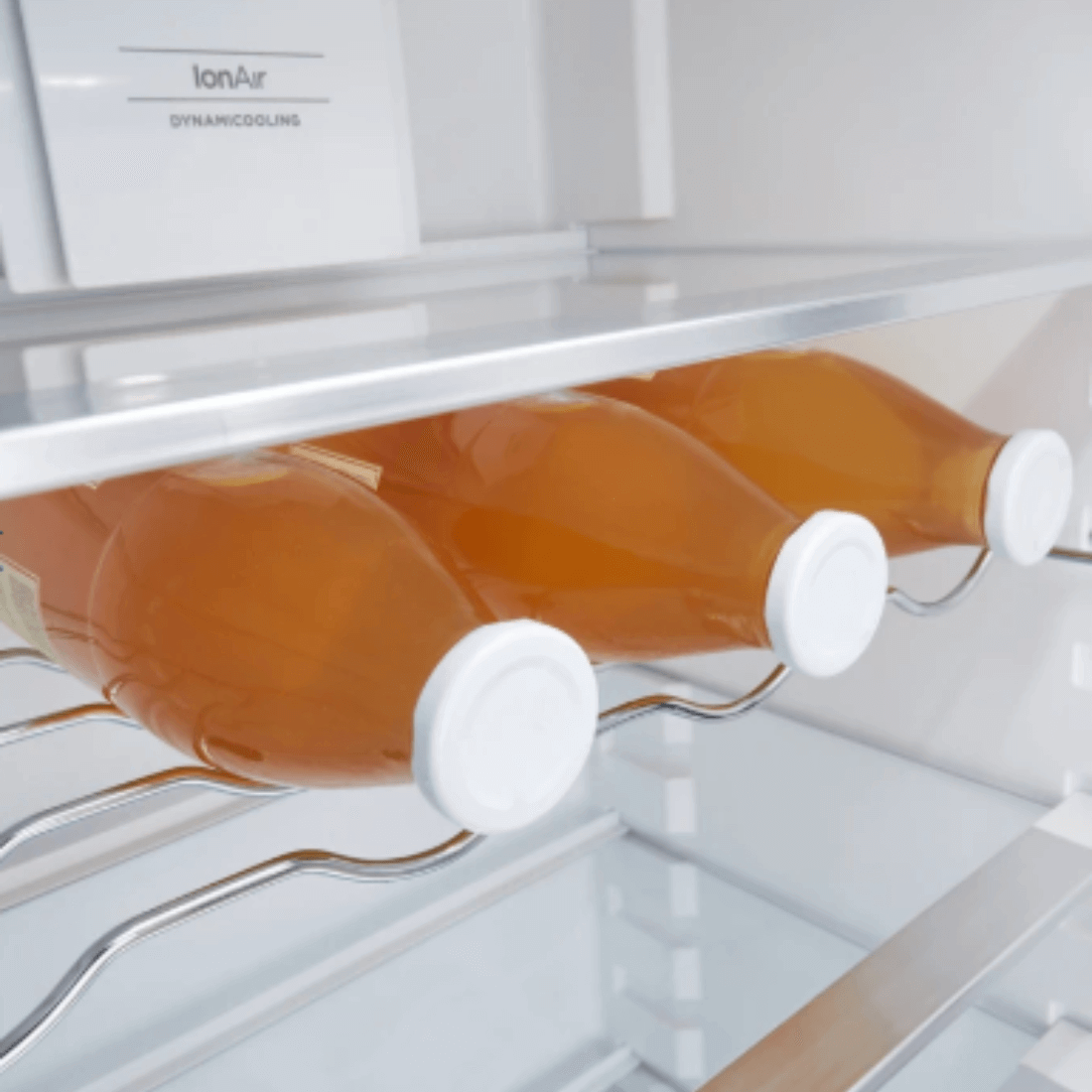 Gôndola interna do refrigerador Gorenje com garrafas de bebida na prateleira, destacando prateleiras de alumínio.