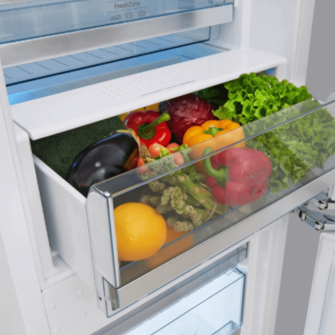 Gaveta do refrigerador Gorenje com vegetais frescos, incluindo alface, pimentões e limão.