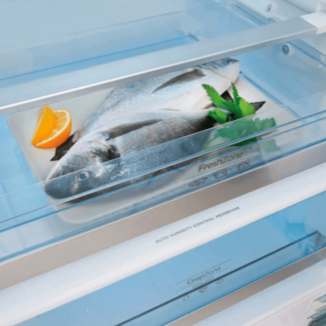 Interior do refrigerador Gorenje com peixe e limão em bandeja na FreshZone, destacando sua funcionalidade.