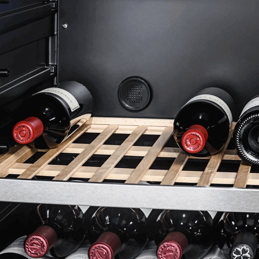Interior da adega Tecno Professional com garrafas de vinho em prateleira de madeira.