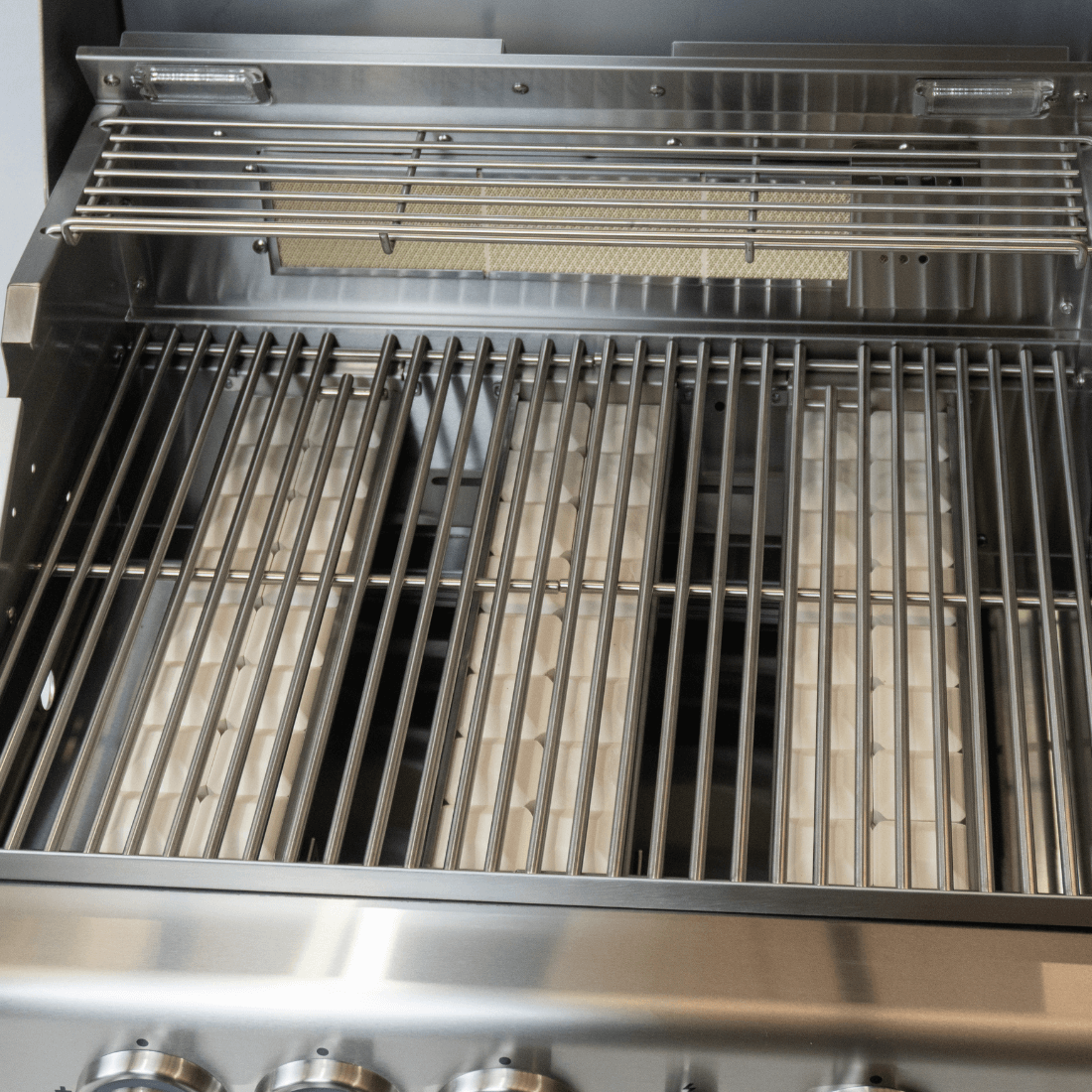 Interior view of Cuisinart Arkton gas grill with stainless steel grates and burners for efficient grilling.