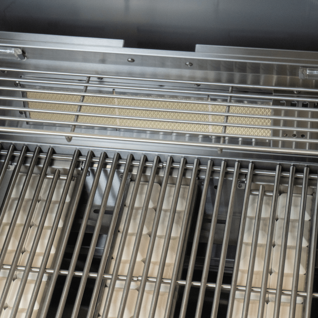 Interior view of Cuisinart Arkton gas grill showcasing stainless steel grates and burners for efficient grilling.