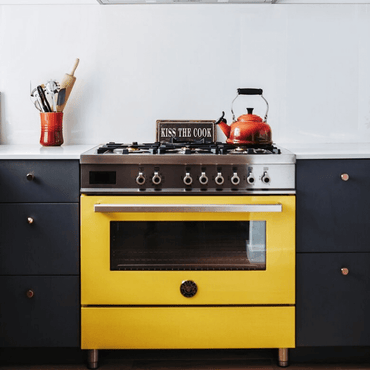 Fogão Bertazzoni amarelo com 6 queimadores e forno elétrico em cozinha moderna.