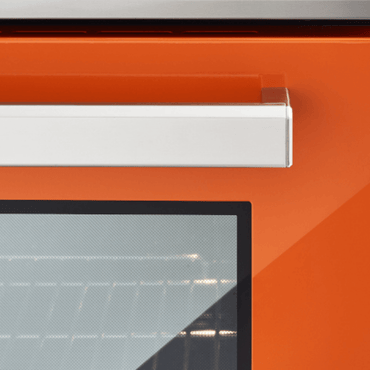 Detalhe da porta do fogão Bertazzoni laranja, com puxador em inox e vidro do forno elétrico.