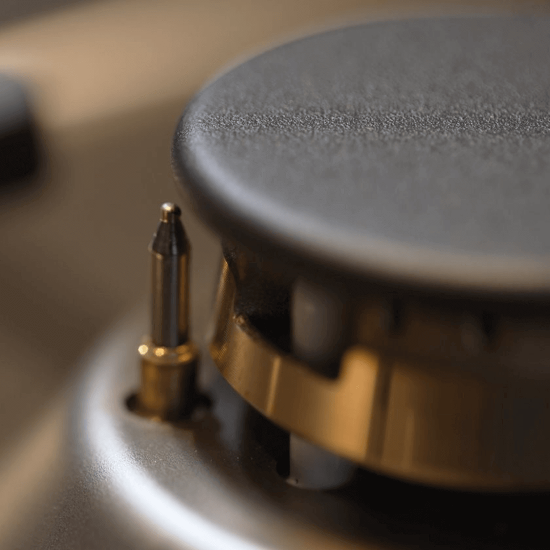 Botão de controle e acendimento do queimador do Fogão Bertazzoni, detalhe em inox e dourado.