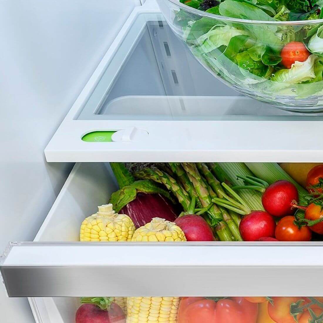 Interior do Refrigerador Tecno com prateleira de vegetais e frutas frescas, destaque para a luz LED e design prático.