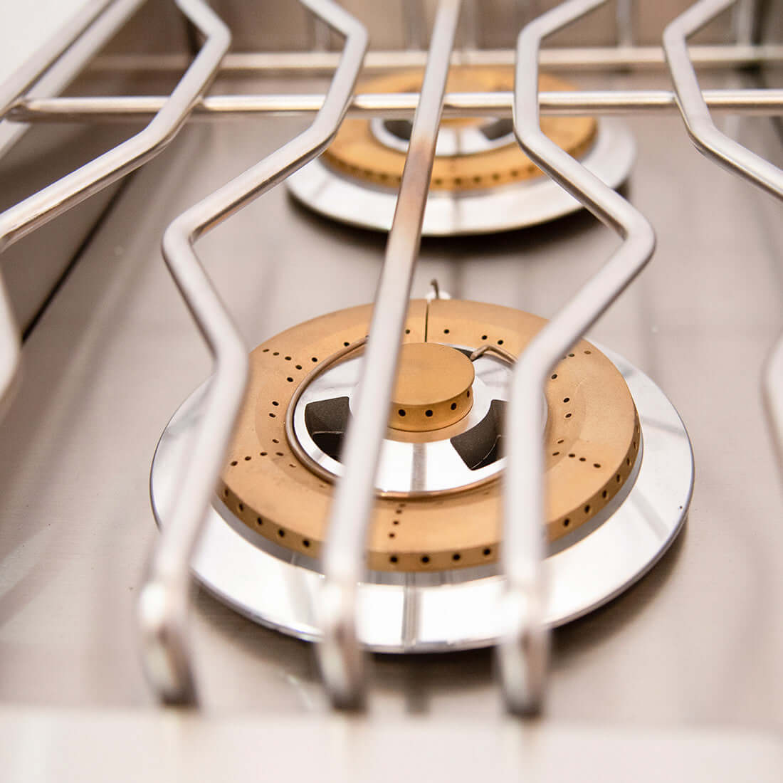 Vista superior dos queimadores tripla chama em inox do cooktop Side Burner Evol com design robusto.