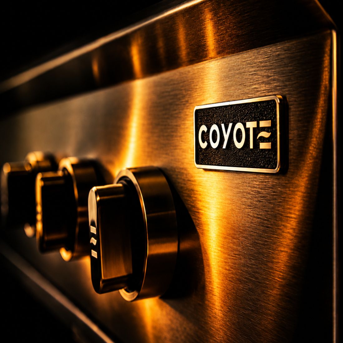 Detalhe da churrasqueira Coyote a gás, com botões e logotipo Coyote em acabamento metálico.