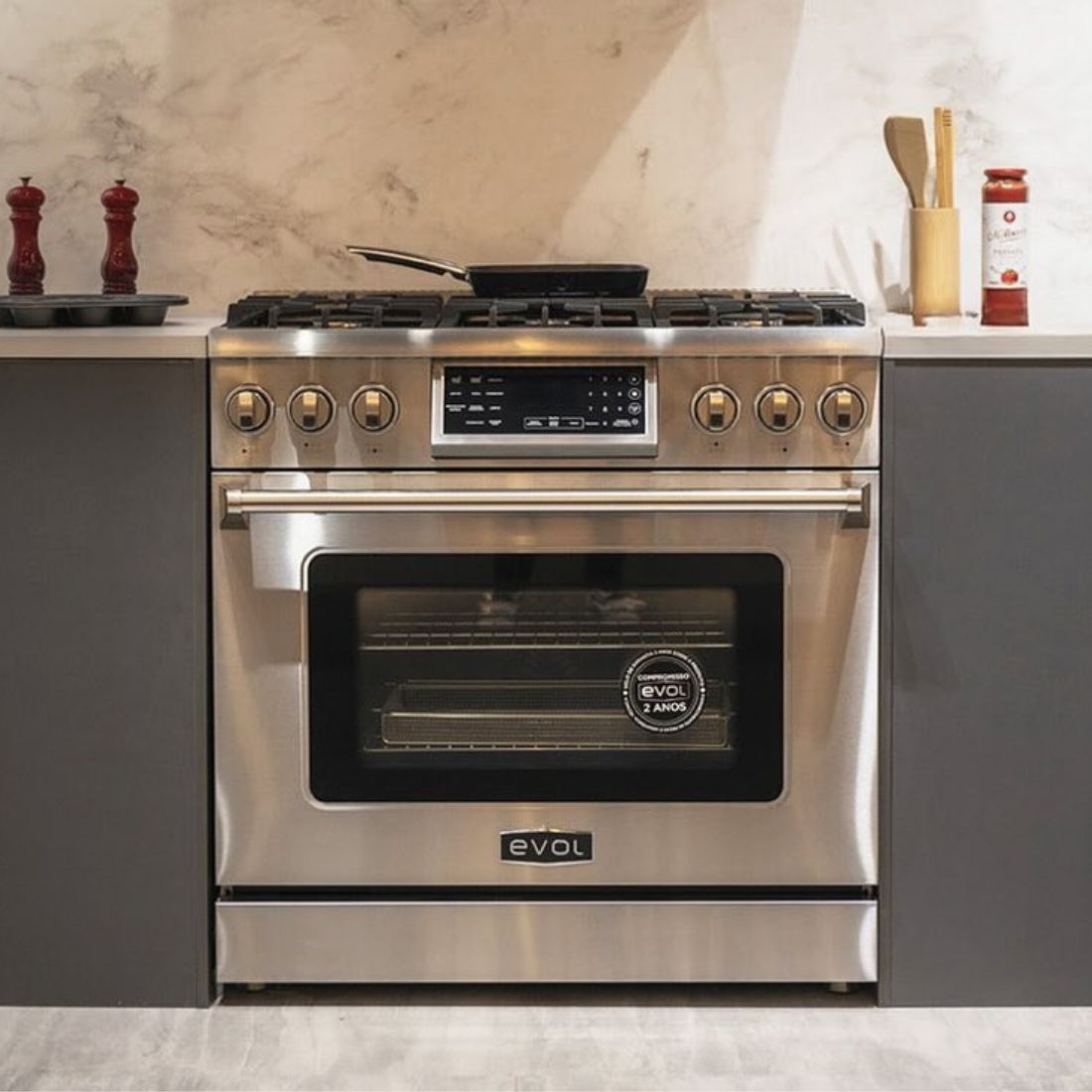Fogão Evol profissional 6 bocas inox com forno elétrico e Air Fryer na cozinha moderna.