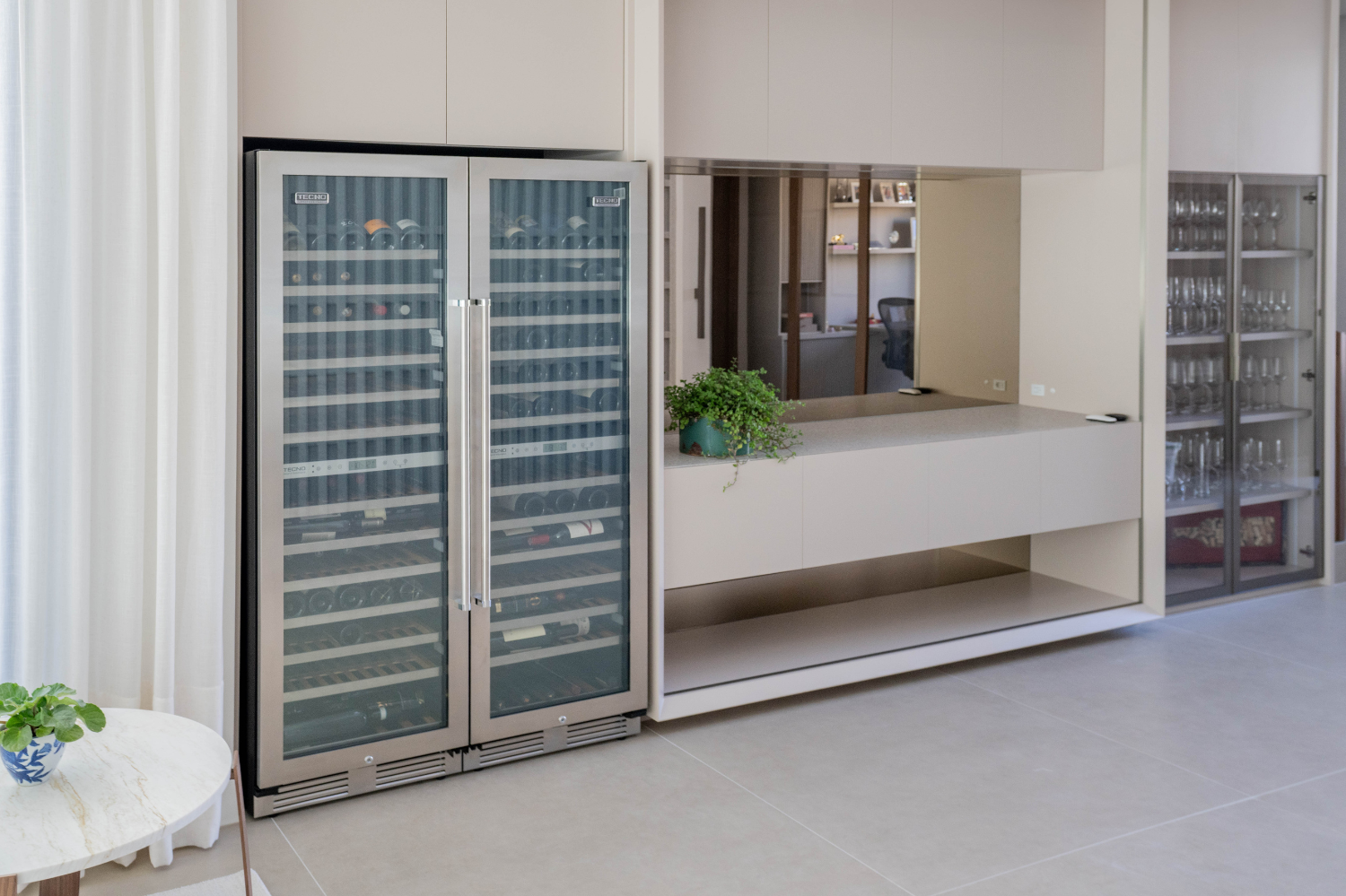 Adegas climatizadas de luxo embutida na cozinha com vista noturna, portas de vidro e prateleiras para vinhos e bebidas