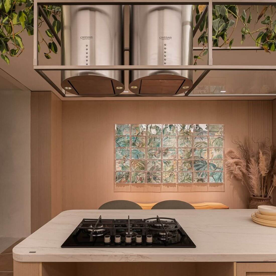 Coifa CrissAir de ilha cilíndrica instalada em cozinha moderna com bancada de mármore.