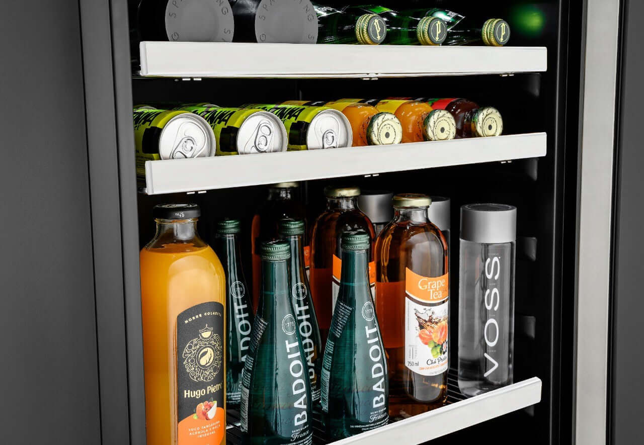 Frigobar de Luxo com porta de vidro aberto exibindo bebidas, latas e frutas para área gourmet