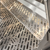 Interior da Churrasqueira a Gás Coyote com grelha em aço inox, ideal para grelhar alimentos.