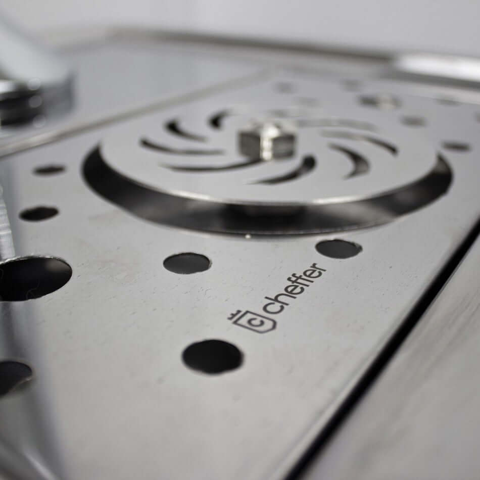 Detalhe da superfície de inox da Chopeira Naja da Cheffer com sistema de drenagem e logotipo.