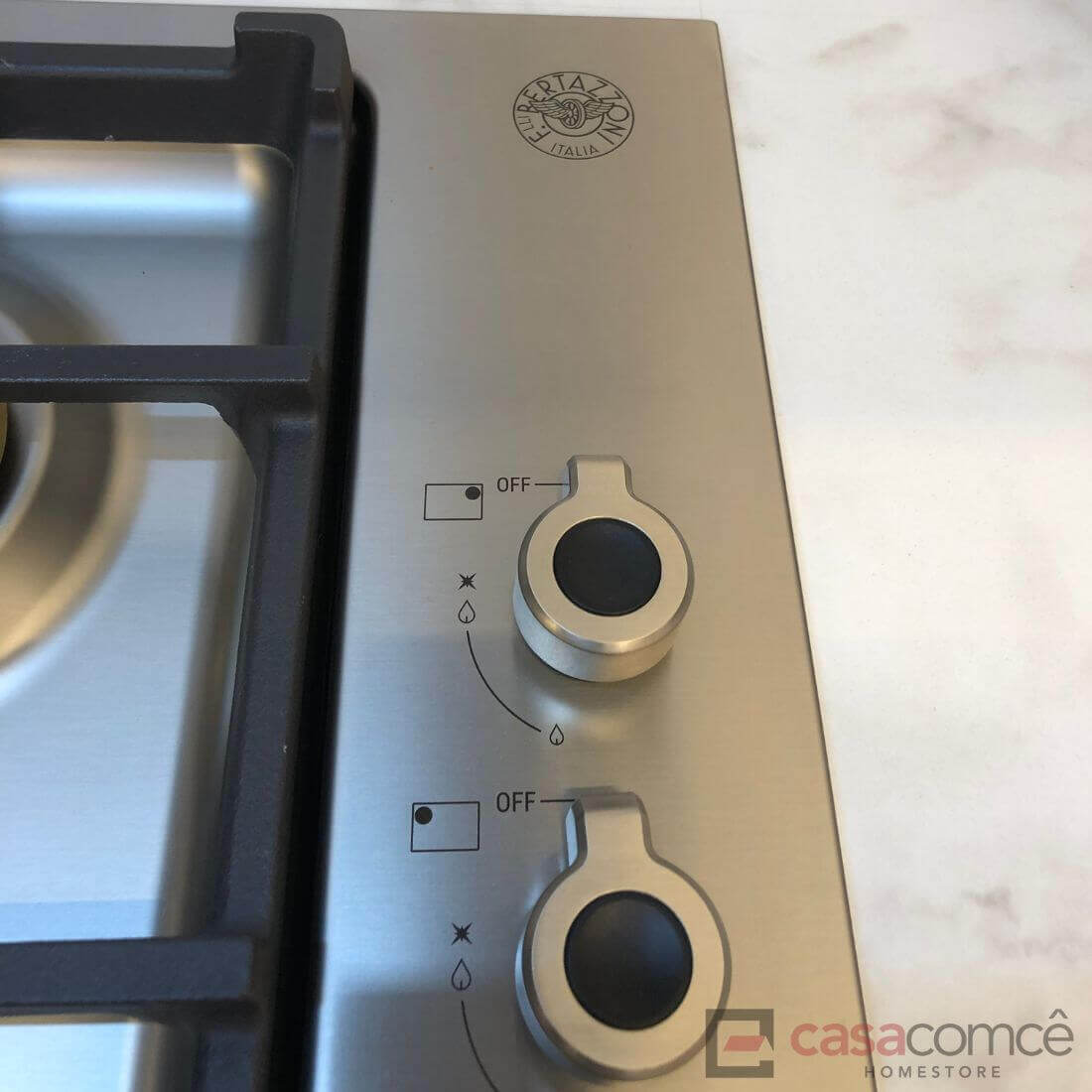 Botões de controle do cooktop Bertazzoni Professional a gás com design em inox e sistema de segurança.