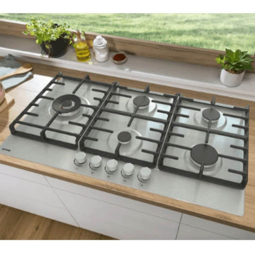 Cooktop a gás Gorenje 5 queimadores 90cm inox sobre bancada de madeira, com design moderno.