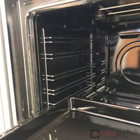 Interior do forno elétrico Bertazzoni com prateleiras de metal e revestimento escovado em inox.