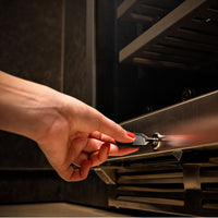 Adega de Vinhos Debacco 94 Garrafas Inox 60cm mostrando mão com chave abrindo adega climatizada em inox embutida, acabamento sofisticado