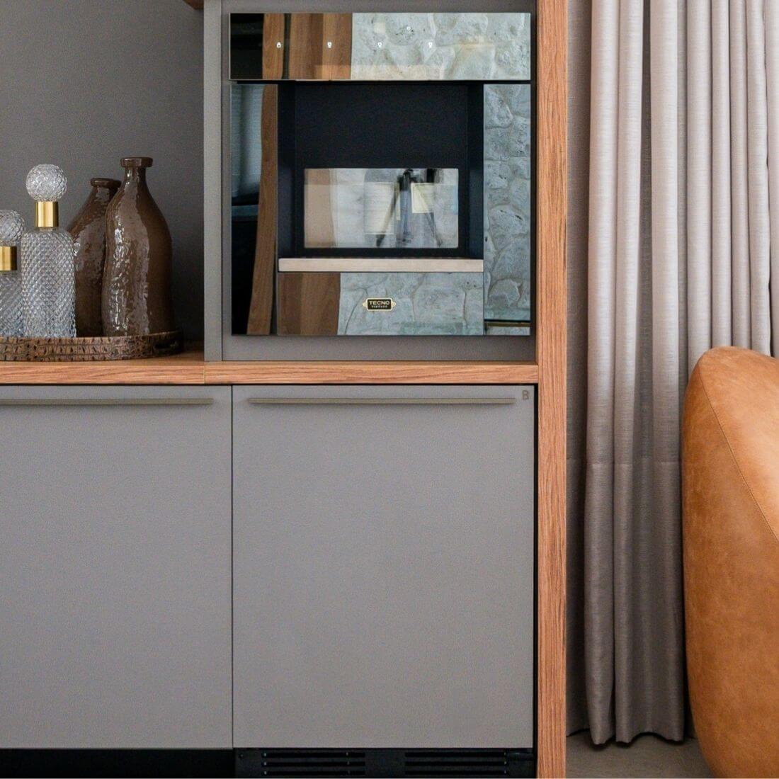 Adega de vinhos Tecno com capacidade para 43 garrafa, ambientada em cenário com revestimento na porta fechada