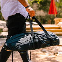 Pessoa transportando a Capa de Proteção Ooni Koda em um ambiente ao ar livre.