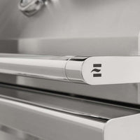 Detalhe da Churrasqueira a Gás Coyote com design em aço inox, mostrando o puxador elegante.