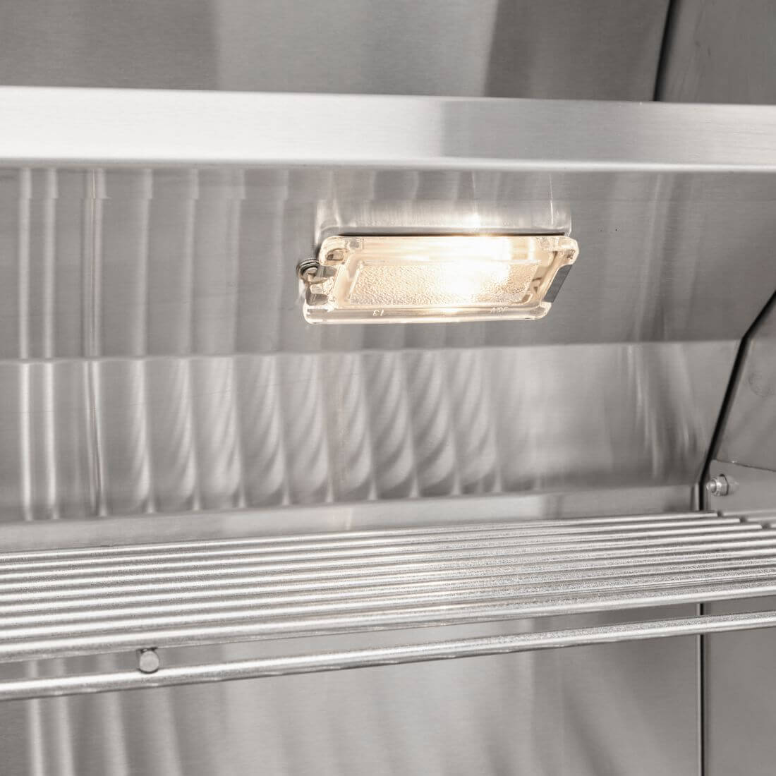 Iluminação interna da Churrasqueira a Gás Coyote, destacando seu design em inox e funcionalidade.