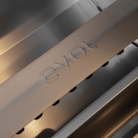 Churrasqueira à Gás Evol Modena 28'' Inox 3 Queimadores 70cm: detalhe do acabamento inox escovado com logo Evol na tampa da grelha