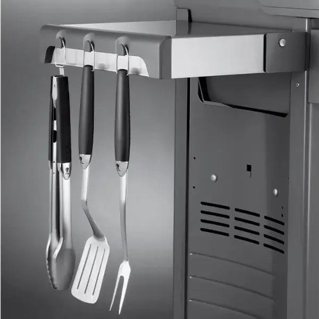 Churrasqueira a Gás Weber 2 Queimadores 120cm com Rodízio Spirit E-210 mostrando lateral com suporte inox, ganchos e utensílios pendurados