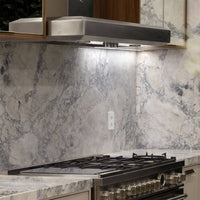 Coifa Bertazzoni Vavano de Parede Inox 122cm: coifa de parede em inox escovado, formato retangular, iluminação e duto visível sobre fogão