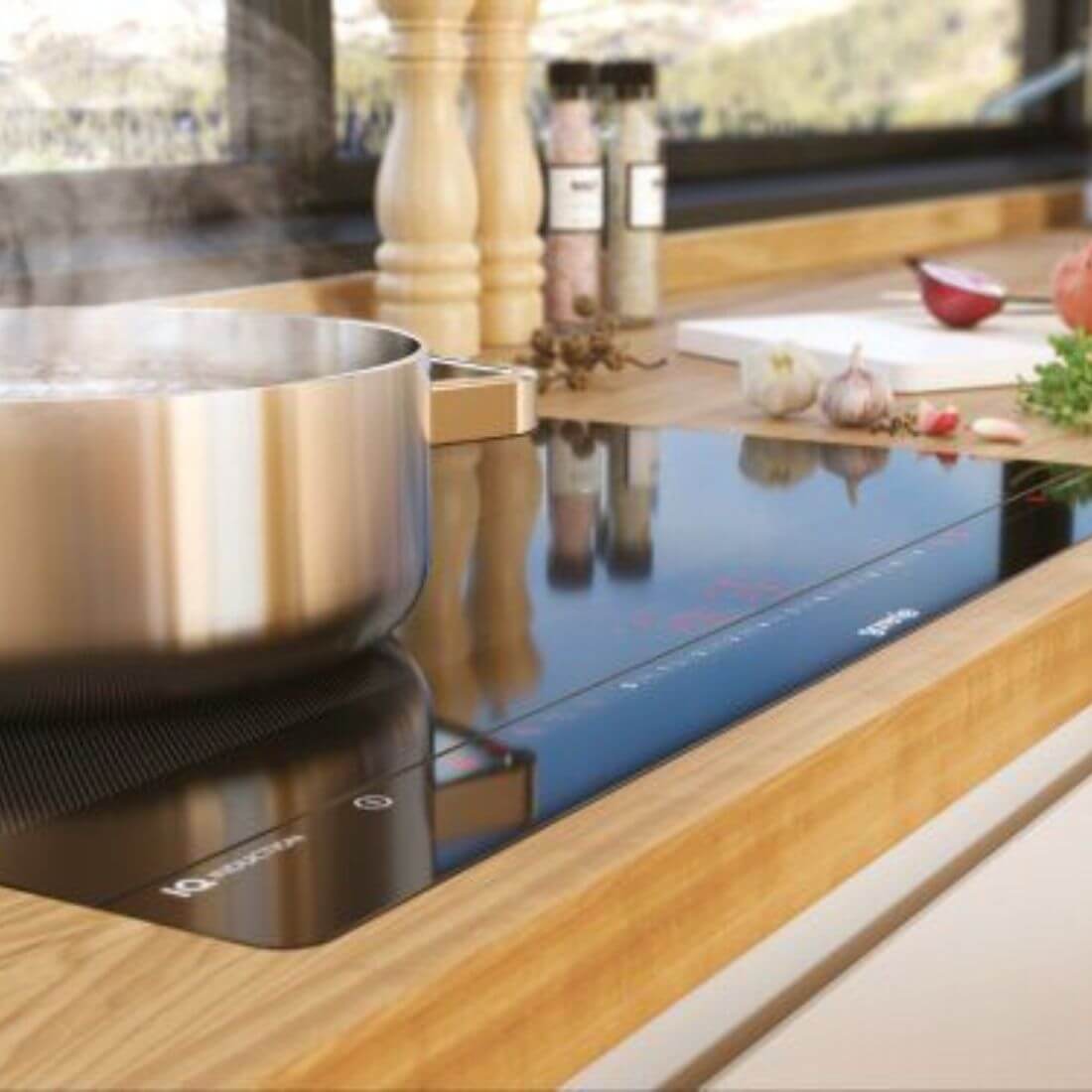 Cooktop de indução Gorenje de 80 cm, com panela e ingredientes, ideal para preparo rápido e intuitivo de refeições.