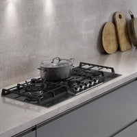 Cooktop de 5 bocas em vidro preto com panela sobre a mesa de cocção, ideal para cozinhas modernas.