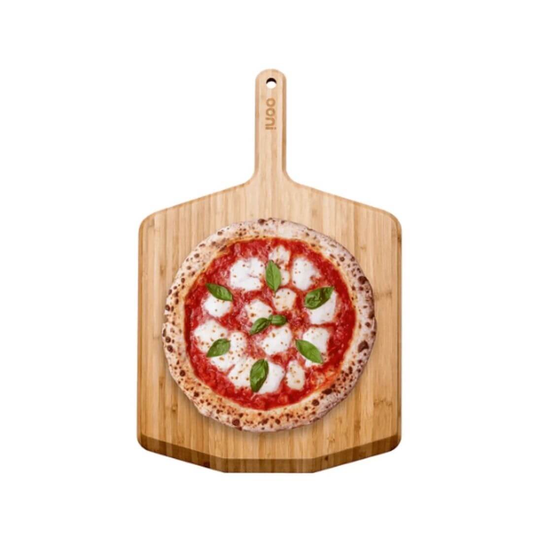 Espátula e Tábua de Bambu Ooni com pizza margherita pronta para servir.