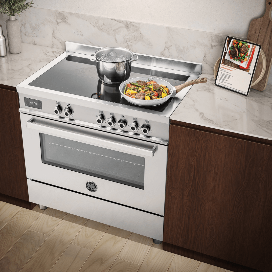 Fogão de indução Bertazzoni com 5 zonas, forno elétrico e design em inox, ideal para cozinhas modernas.