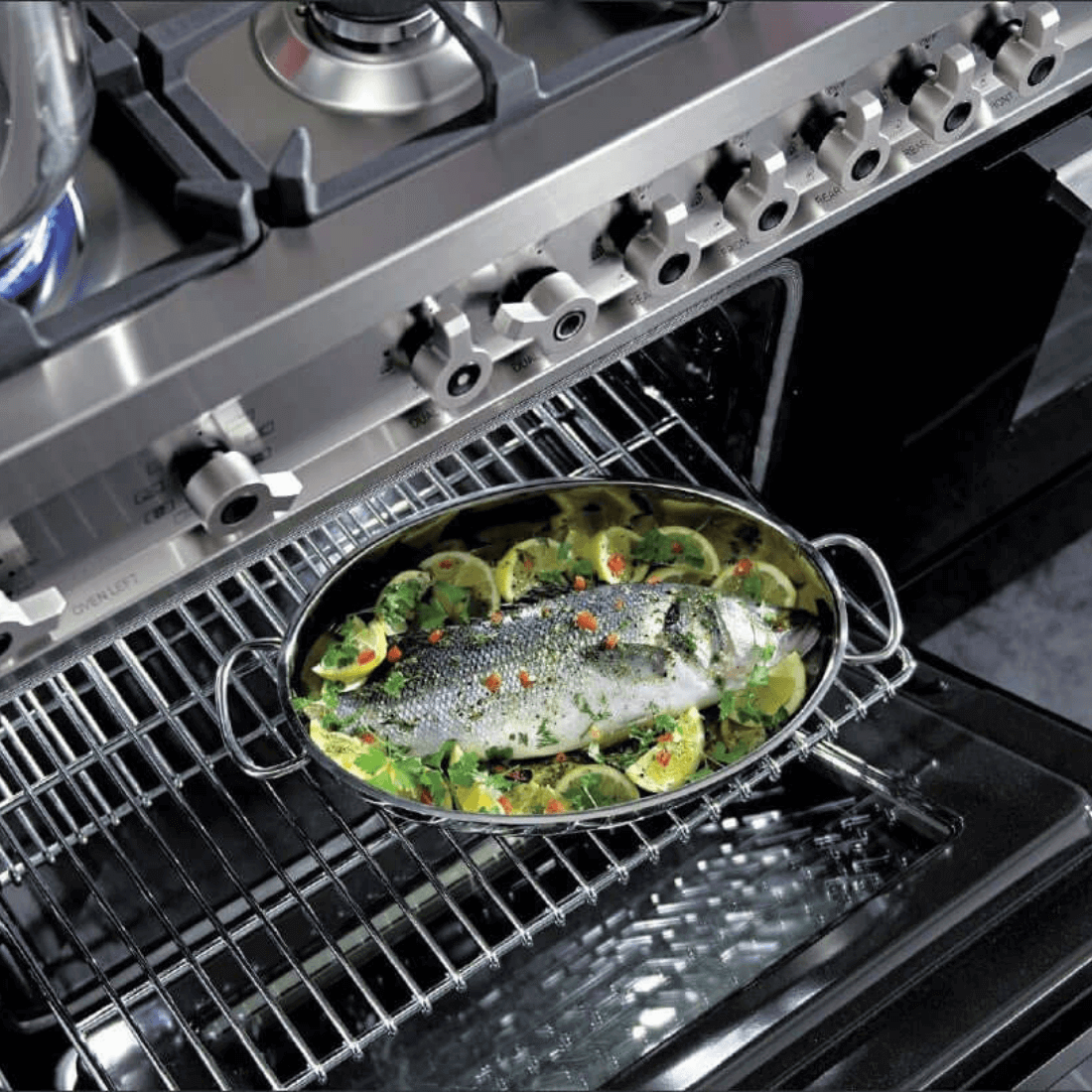 Fish dish cooking in Bertazzoni oven with fresh vegetables on a stainless steel grill.