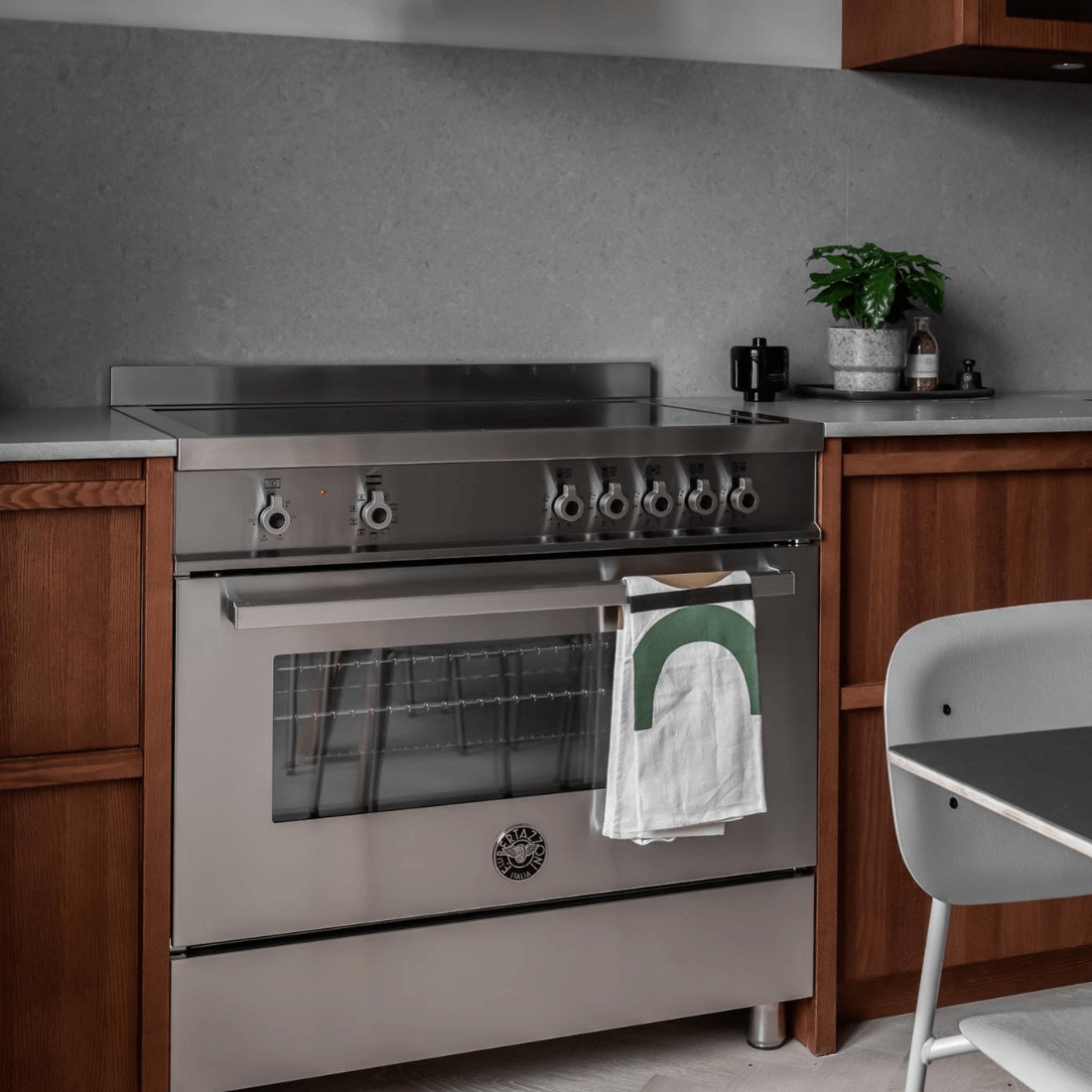Fogão Bertazzoni Professional inox 90cm com mesa de indução e forno elétrico em cozinha moderna.
