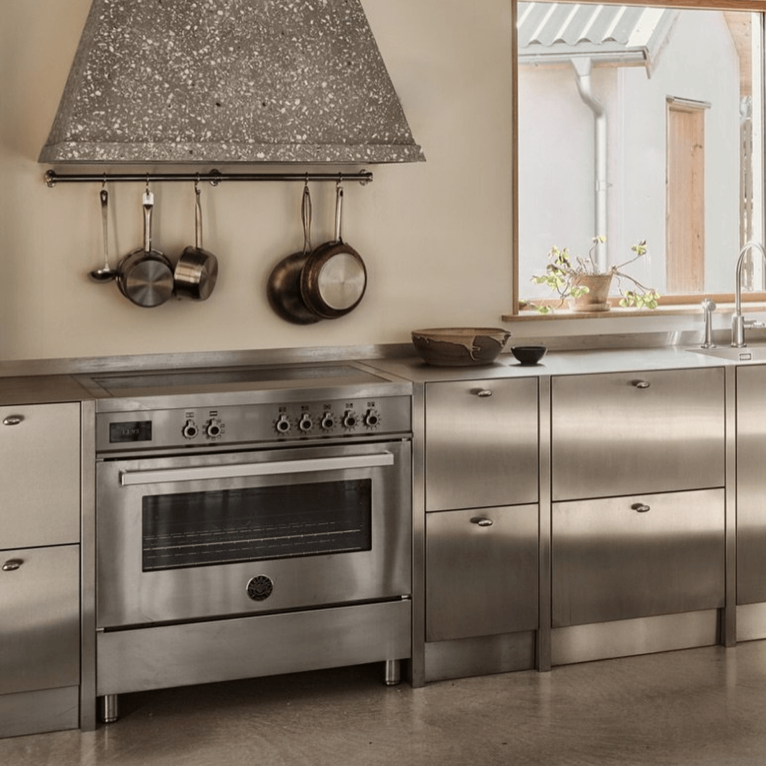 Fogão Bertazzoni Professional em inox com indução e forno elétrico em cozinha moderna.