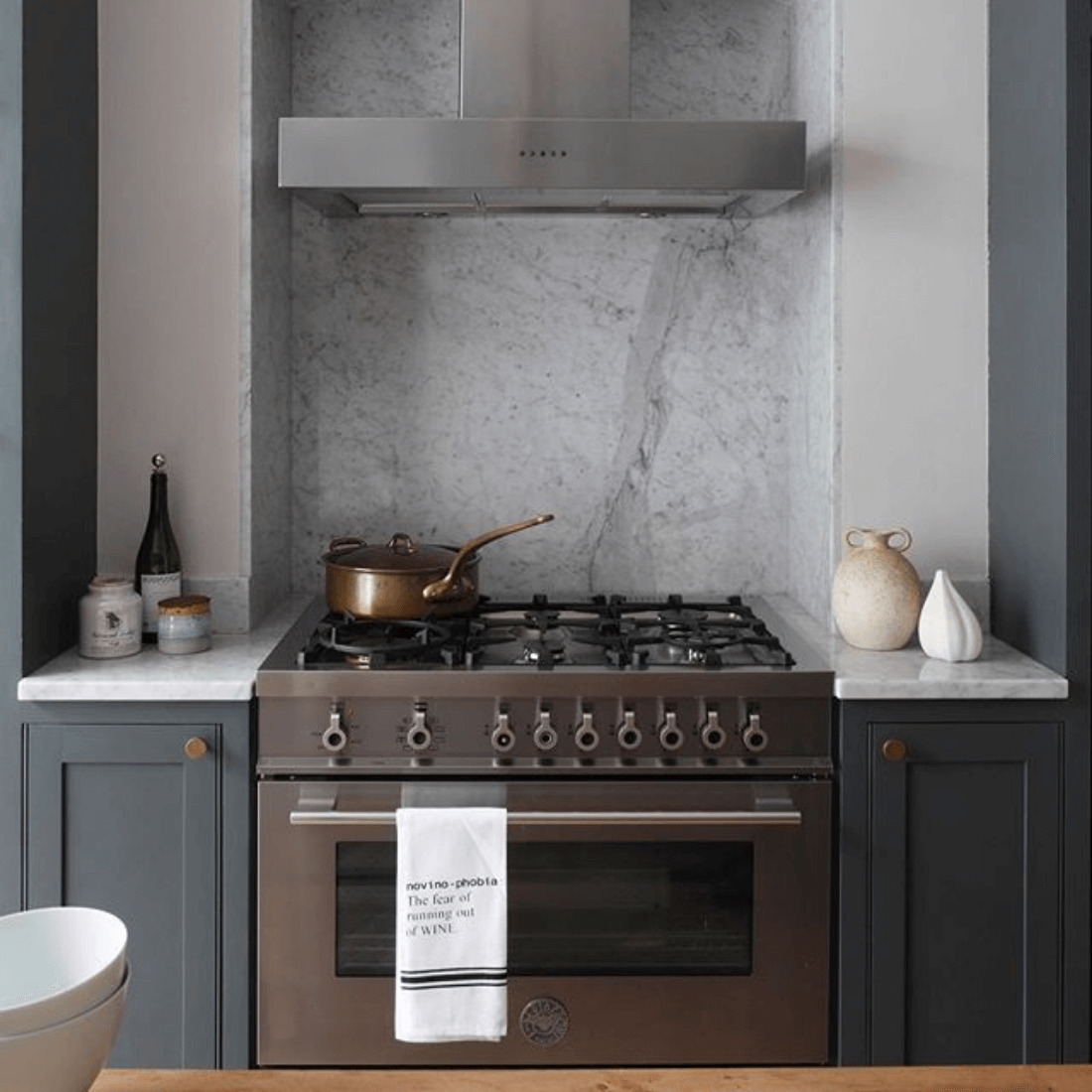 Fogão de gás moderno com forno e coifa em ambiente elegante de cozinha, decoração minimalista.