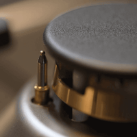 Fogão Bertazzoni Professional Vermelho 90cm 6 Bocas Forno Elétrico 108L close-up de queimador Sabaf em latão com trempe de ferro e acabamento inox escovado