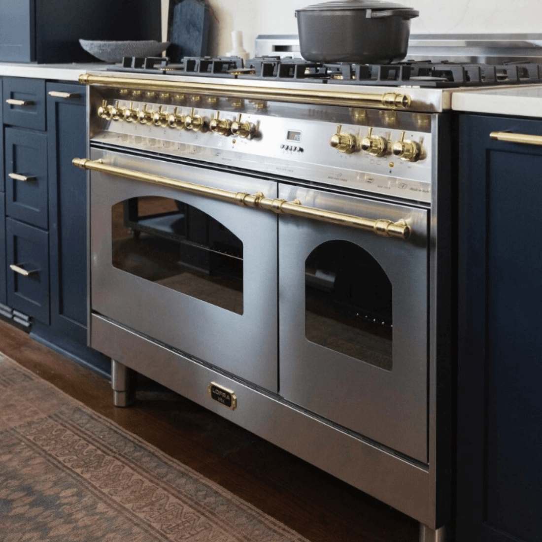 Alt Tag: Fogão Lofra Dolcevita Inox 120cm 7 Bocas Forno Elétrico Duplo 124L - fogão de piso inox escovado com 7 bocas, fornos duplos elétricos, puxadores dourados e grelhas profissionais