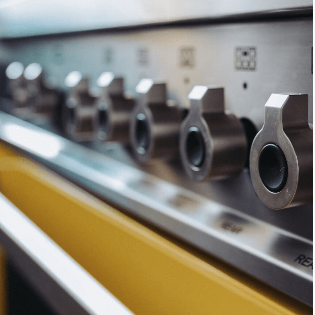 Fogão Bertazzoni Professional Amarelo 120cm 6 Bocas Forno Duplo 138L em piso, inox escovado amarelo, puxadores e painel de controle metálico visíveis