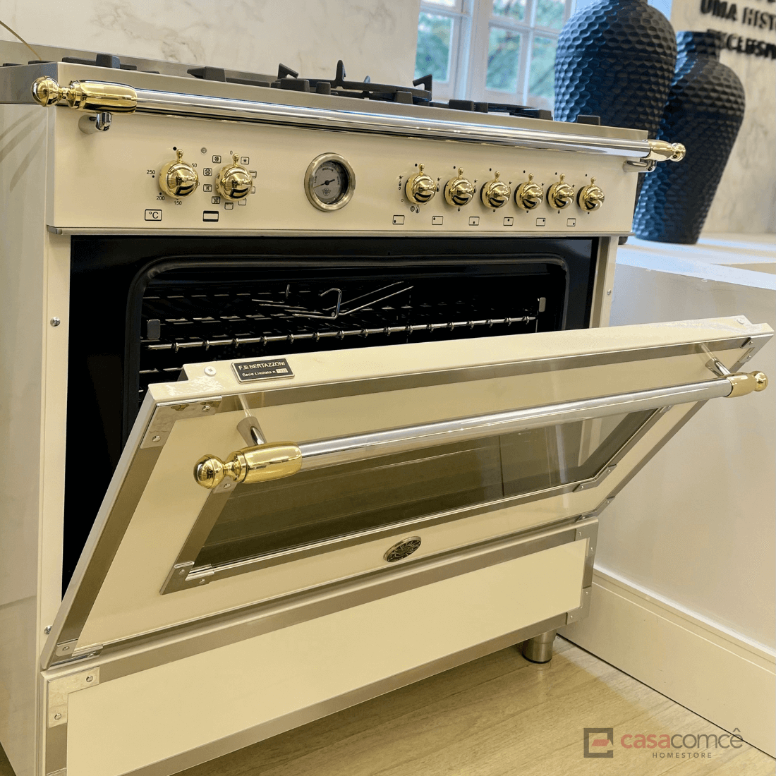 Fogão Bertazzoni Heritage Marfim 90cm 6 Bocas Forno Elétrico 103L: fogão de piso creme com 6 bocas, forno elétrico aberto, puxadores dourados e grelhas ferro fundido