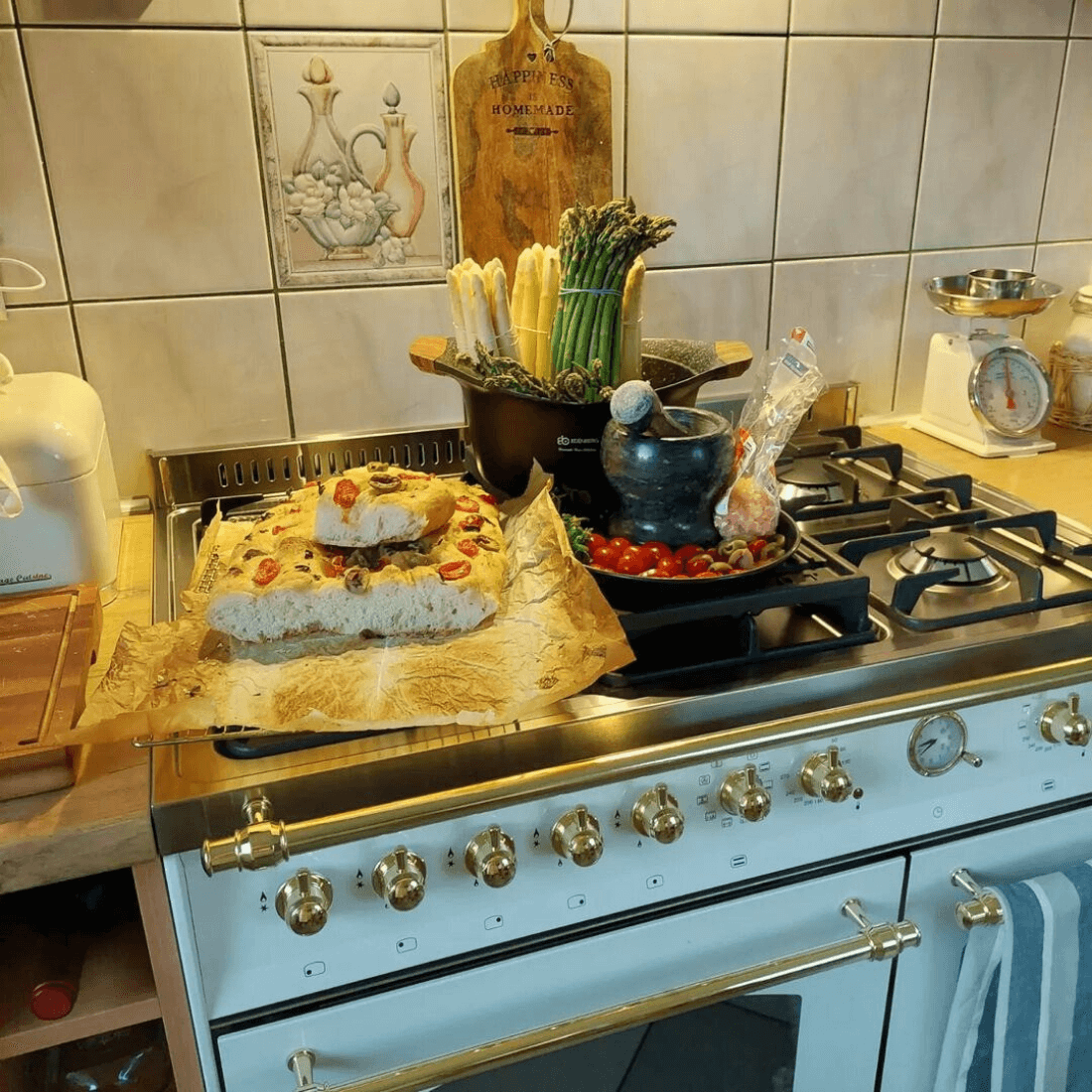 Fogão com bolo, vegetais e utensílios de cozinha em ambiente sofisticado e aconchegante.