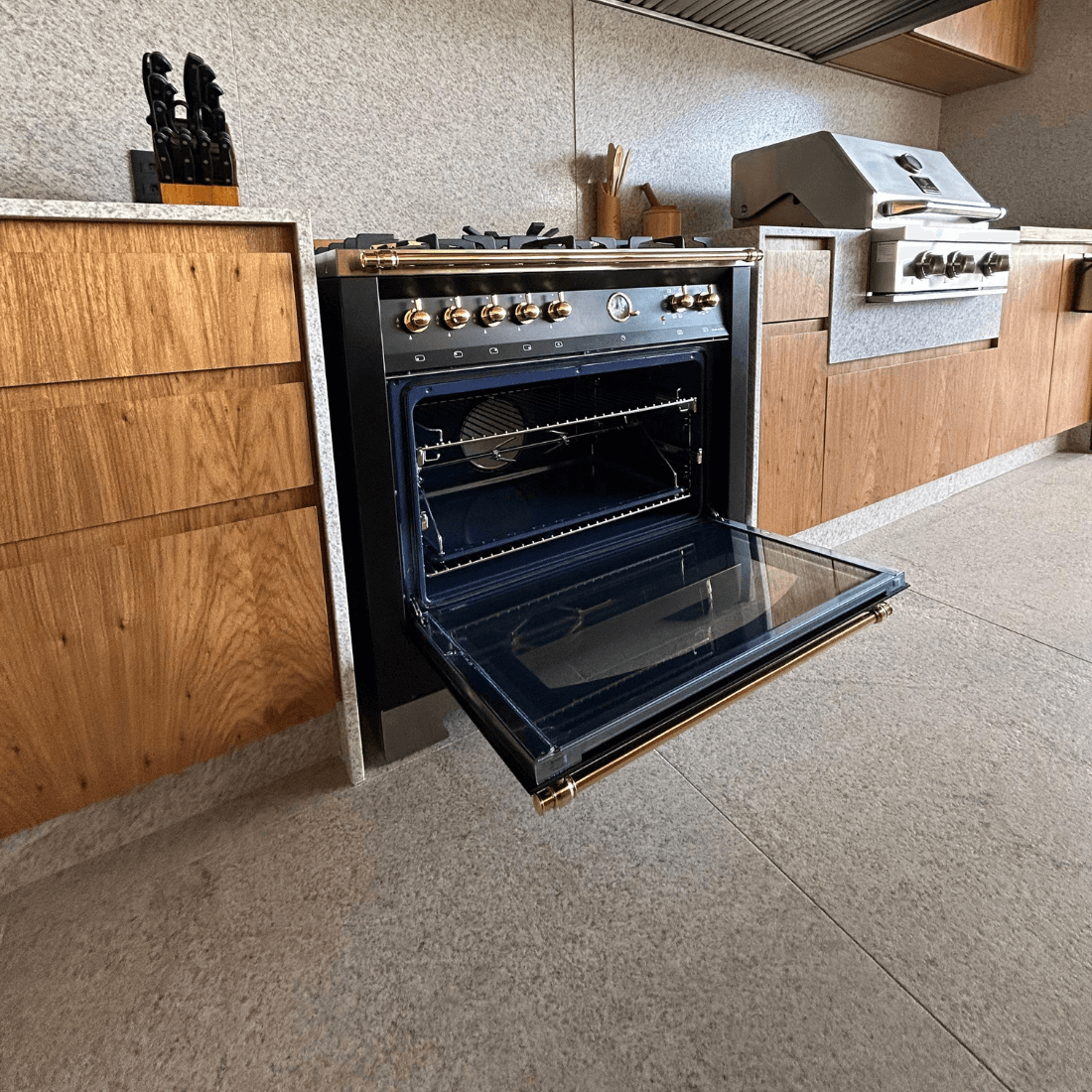 Fogão Lofra Vintage Dolcevita preto com forno elétrico de 102 litros e 5 queimadores na cozinha moderna.