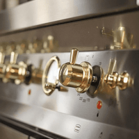 Fogão Lofra Dolcevita Inox 90cm 5 Bocas Forno Elétrico 102L de piso em inox com botões dourados, painel inox e puxadores estilo profissional