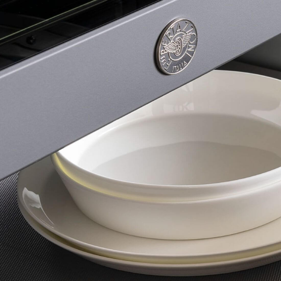 Gaveta Aquecida Bertazzoni Master 10 Serviços Inox 76cm em inox escovado com puxador tubular e interior preparando pratos para aquecimento